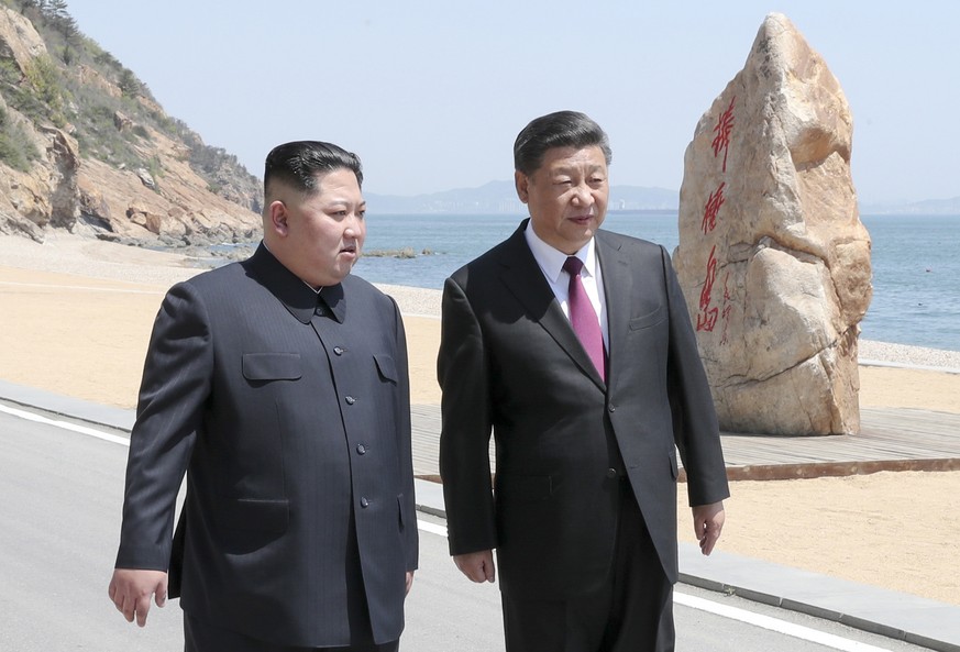 In this photo taken between May 7 and 8, 2018 released by Xinhua News Agency, Chinese President Xi Jinping, right, walks with North Korean leader Kim Jong Un during a meeting in Dalian in northeastern ...