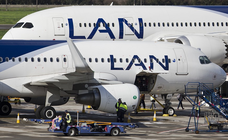 Two LAN jet liners sit parked on the tarmac at the airport in Santiago, Chile, Monday, July 25, 2016. LATAM airlines created in 2012 after a fusion between the airlines LAN of Chile and TAM of Brazil, ...