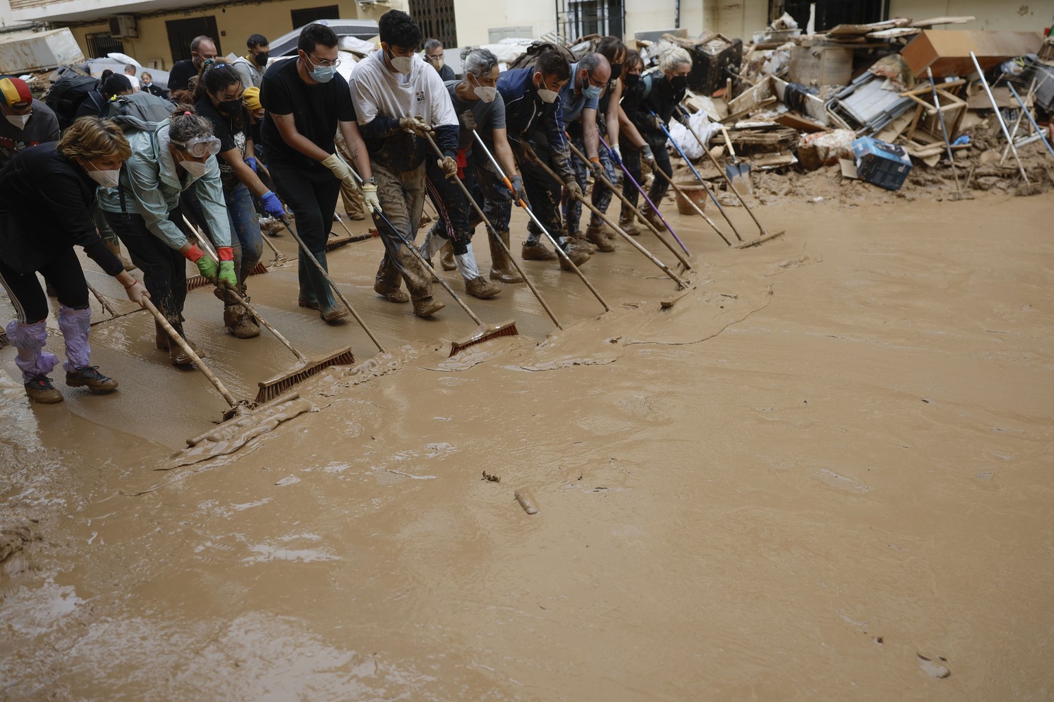 epa11698967 Residents clean a street after flash floods in Alfafar, province of Valencia, eastern Spain, 03 November 2024. Rains have left more than 200 dead, an undetermined number of missing people, ...