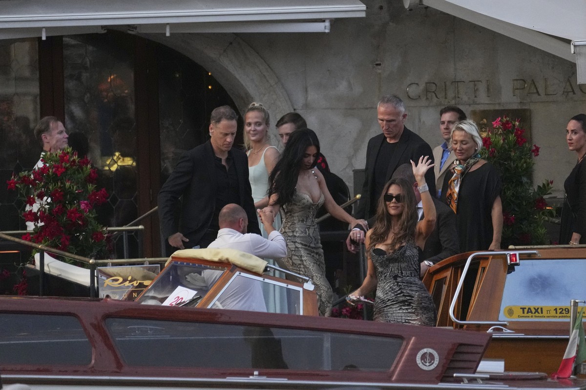 Kim Kardashian, center left, and Khloe Kardashian, center right, leave a hotel for the pre wedding reception of Amazon founder Jeff Bezos and Lauren Sanchez, in Venice, Italy, Thursday, June 26, 2025. ...