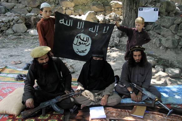 epa04868674 A picture made available on 01 August 2015 shows Gul Dali (R) the district leader of Islamic State (IS) sitting with colleagues and his family at an undisclosed location in Kunar province, ...