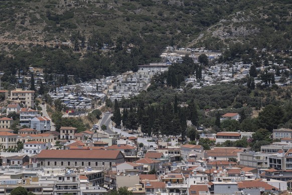 This shows the port city of Vathy and the refugee and migrant camp, top, in the eastern Aegean island of Samos, Greece, on Friday, June 11, 2021. An inflatable dinghy carrying nearly three dozen peopl ...