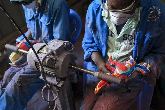 epa10228962 Kenyan artists from the social enterprise &#039;Ocean sole&#039; give some finishing touches to colorful animal figures made from old flip-flops at their workshop in Nairobi, Kenya, 06 Oct ...