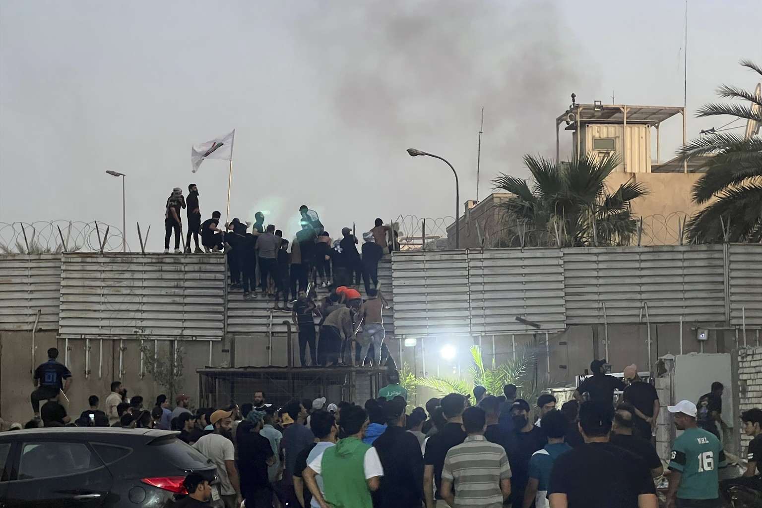 Protesters scale a wall at the Swedish embassy in Baghdad on Thursday, July 20, 2023. Protesters angered by the burning of a copy of the Quran stormed the embassy early Thursday morning and broke into the complex…