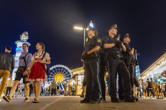 Abendstimmung Kunstlicht Riesenrad Polizei steht in Kreis Formation / Impressionen auf dem Oktoberfest Wiesn in M�nchen / Datum: 19.09.2023 / *** Evening mood artificial light Ferris wheel police stan ...