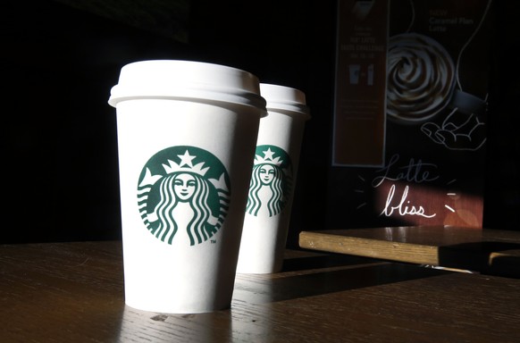 FILE - In this this Friday, Jan. 17, 2014, file photo, Starbucks cups are shown mugs in a cafe in North Andover, Mass. Starbucks announced July 12, 2016, that it was raising prices slightly on brewed  ...