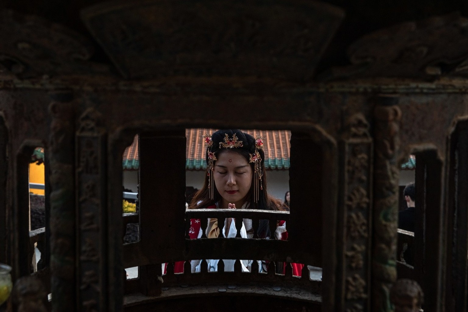 epa08914018 A woman prays at Patong Temple on the first day of the new year, in Wuhan, China, 01 January 2021.  Life in Wuhan, a Chinese city of more than 11 million, which nearly a year ago ...