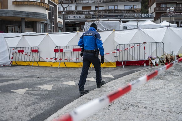 A policeman of the Valais Cantonal Police secures the area in front of the blocked off 'Le Constellation' bar and lounge, where a fire broke out during New Year's celebration, in Crans- ...