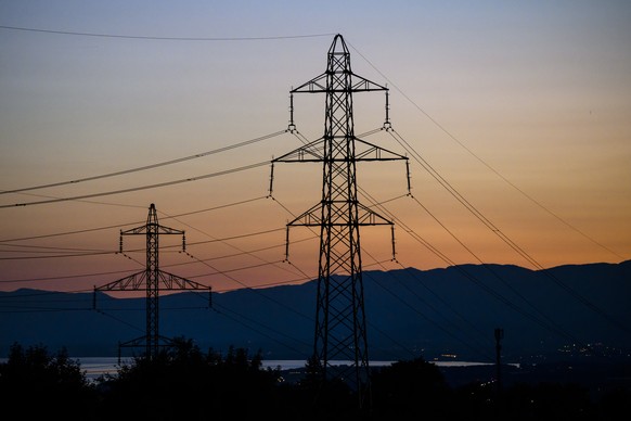 Le soleil se couche derriere les pylones de la ligne a haute tension du reseau electrique le dimanche 18 septembre 2022 a Romanel. La crise energetique fait exploser les prix de l&#039;electricite dan ...