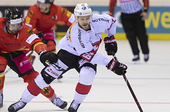 Germany&#039;s Nicolas Kraemmer, left, fights for the puck against Switzerland&#039;s Christoph Bertschy, right, during the Ice Hockey Deutschland Cup match between Germany and Switzerland at the Koen ...