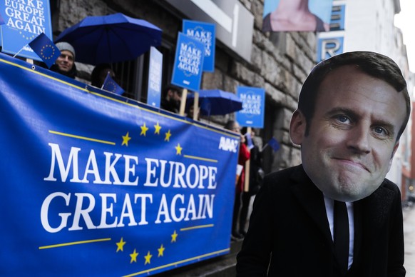 Activists of the AVAAZ network, one with a mask of France&#039;s President Emmanuel Macron, attend a demonstration to support the European politic of Macron near the German Social Democratic Party&#03 ...