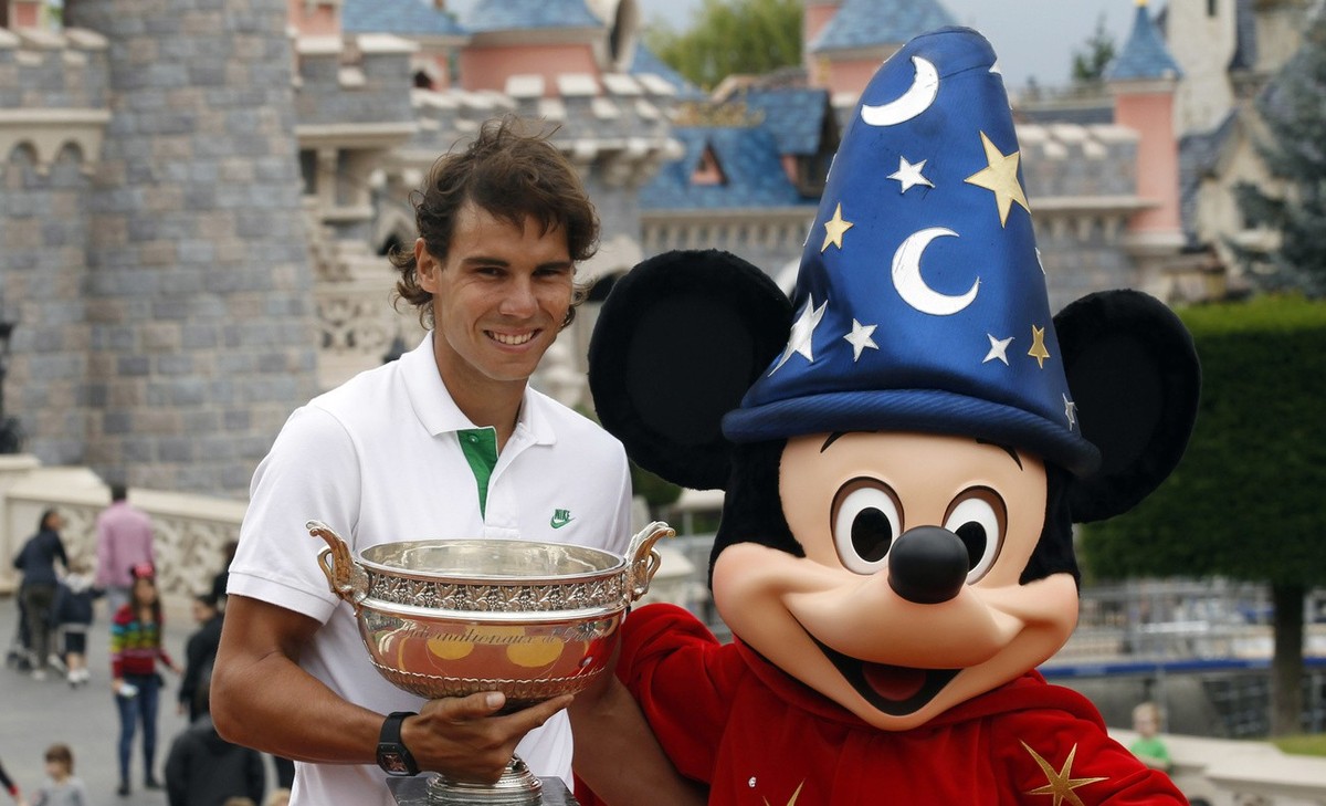 Spain's Rafael Nadal holds the trophy as he poses with Mickey Mouse during a photocall at the Disneyland Paris theme park in Marne-la-Vallee, east of Paris, Monday June 6, 2011. Nadal defeated Ro ...