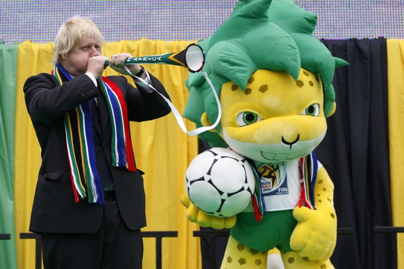 FILE - In this Friday, June 11, 2010 file photo, then Mayor of London, Boris Johnson blows a vuvuzela beside the South Africa World Cup&#039;s mascot Zakumi during a special event to mark the start of ...