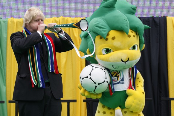 FILE - In this Friday, June 11, 2010 file photo, then Mayor of London, Boris Johnson blows a vuvuzela beside the South Africa World Cup's mascot Zakumi during a special event to mark the start of ...