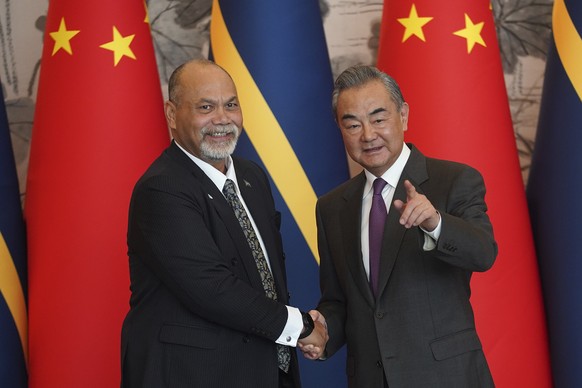 Chinese Foreign Minister Wang Yi, right, and Minister of Foreign Affairs and Trade of Nauru Lionel Aingimea shake hands after signing the joint communique on the resumption of diplomatic relations bet ...