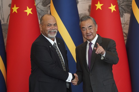 Chinese Foreign Minister Wang Yi (right) and Nauru Minister of Foreign Affairs and Trade Lionel Aingimea shake hands after signing the joint communiqué on the resumption of diplomatic relations between…