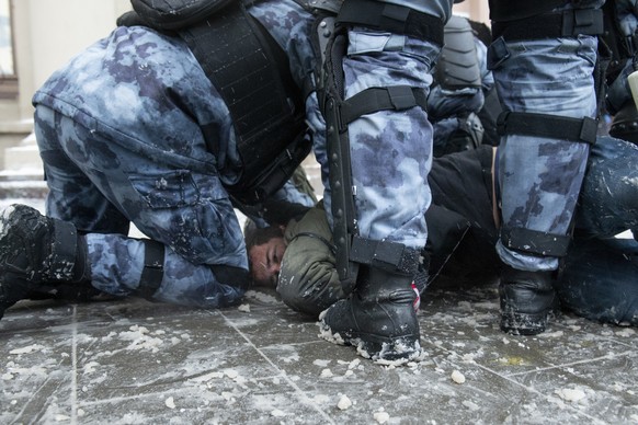 Police officers detain a man during a protest against the jailing of opposition leader Alexei Navalny in Moscow, Russia, on Sunday, Jan. 31, 2021. Tens of thousands of people are protesting across Rus ...