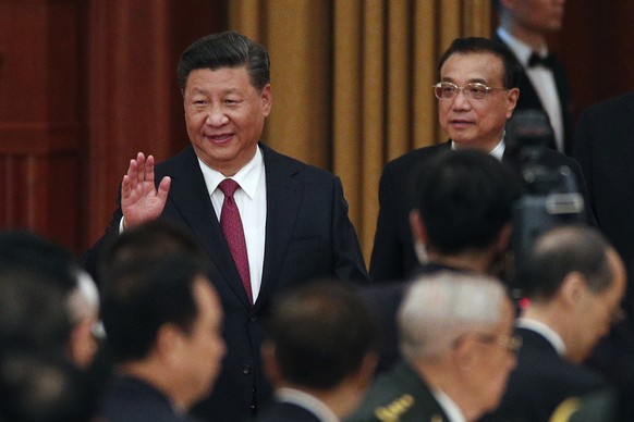 Chinese President Xi Jinping, left, waves as he arrives with his Premier Li Keqiang to a dinner marking the 69th anniversary of the founding of the People's Republic of China at the Great Hall of the  ...