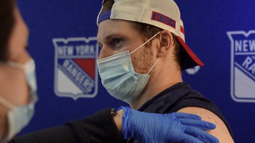 This photo provided by the New York Rangers shows New York Rangers NHL hockey defenseman Jacob Trouba receiving a dose of COVID-19 vaccine at Madison Square Garden in New York on Wednesday, April 7, 2 ...