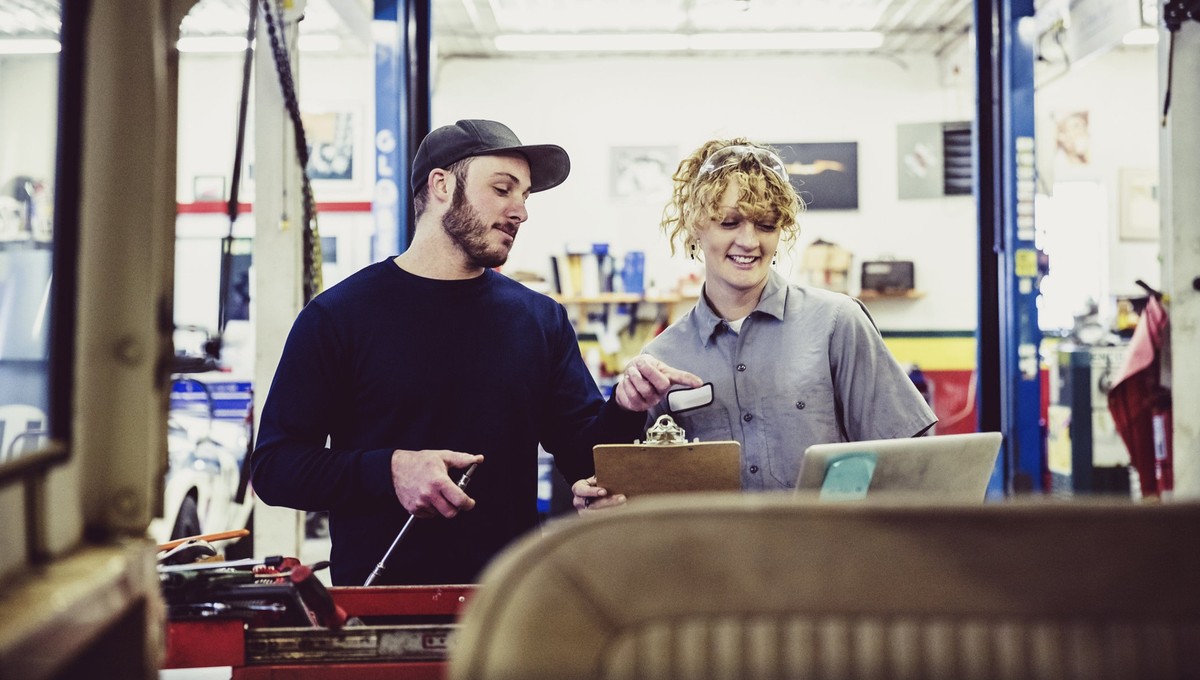 Female, Garage, Blue Collar, Employment, Candid, Engineers, Mechanics - Female mechanic with her colleague at a service station