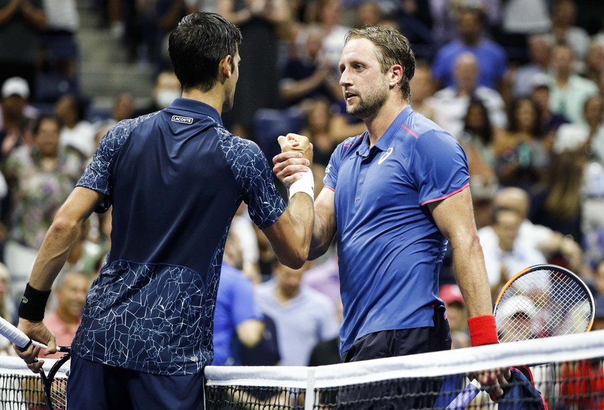 epa06985799 Novak Djokovic of Serbia (L) shakes hands with Tennys Sandgren (R) of the United States after their match during the fourth day of the US Open Tennis Championships the USTA National Tennis ...