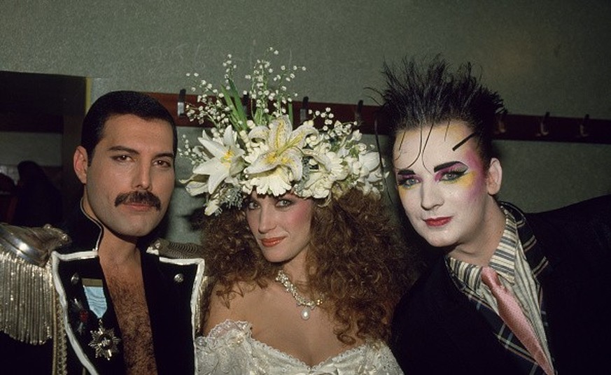 LONDON, ENGLAND - NOVEMBER 5: British singers Boy George (right) and Freddie Mercury of Queen (left) with actress Jane Seymour backstage at the Fashion Aid event at the Royal Albert Hall in London, En ...