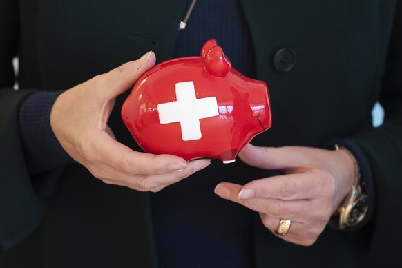 Bundesraetin Karin Keller-Sutter, neue Finanzministerin, haelt das Sparschwein, das sie vom zurueckgetretenen Bundesrat Ueli Maurer, erhalten hat, bei der Schluesseluebergabe im EFD, am Dienstag, 20.  ...