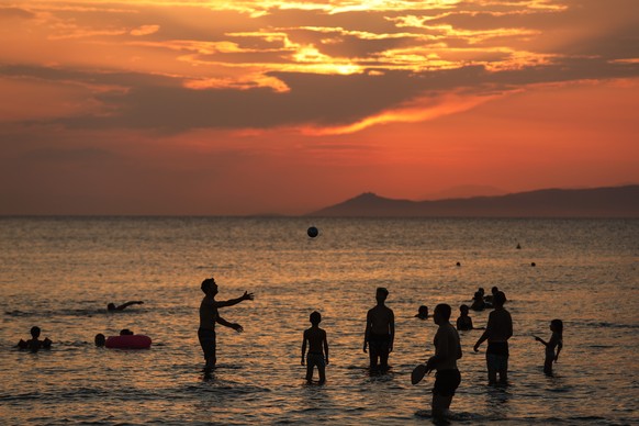epa11554623 People enjoy the sunset from Kavouri beach south of Athens, Greece, 18 August 2024. EPA/GEORGE VITSARAS