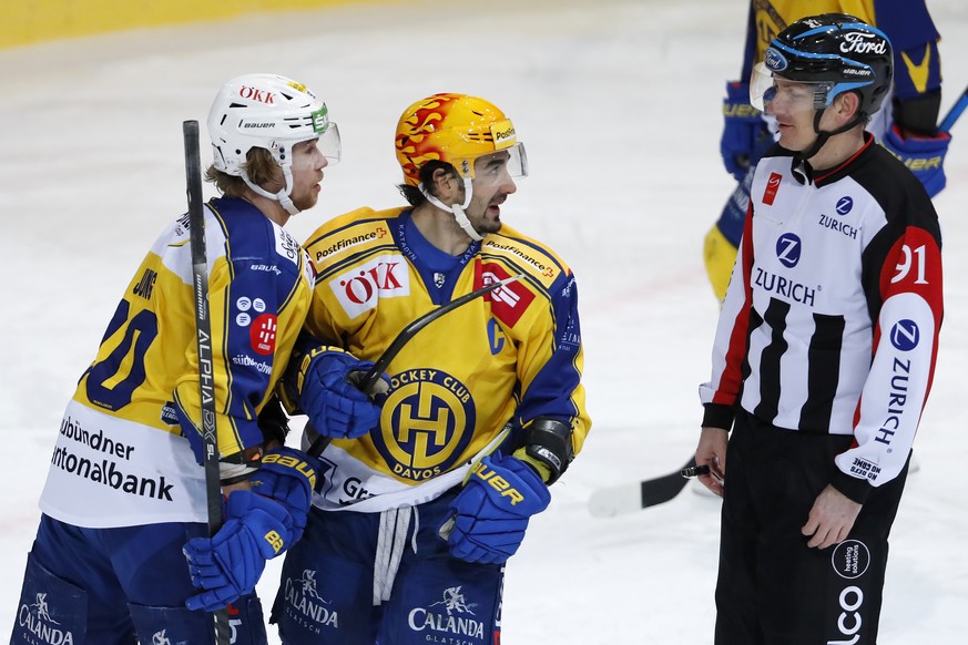 Davos&#039; PostFinance Top Scorer Andres Ambuehl, Mitte, und Teamkollege Sven Jung diskutieren mit Schiedsrichter Daniel Stricker, im Eishockey Meisterschaftsspiel der National League zwischen dem SC ...