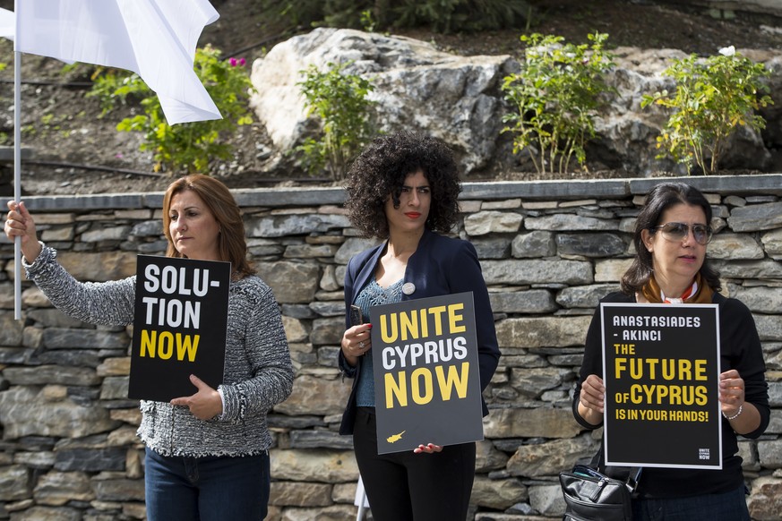 Supporters of the peace hold placards at the begining of a new round of the conference on Cyprus under the auspices of the United Nations, in Crans-Montana, Switzerland, Wednesday, June 28, 2017. (KEY ...