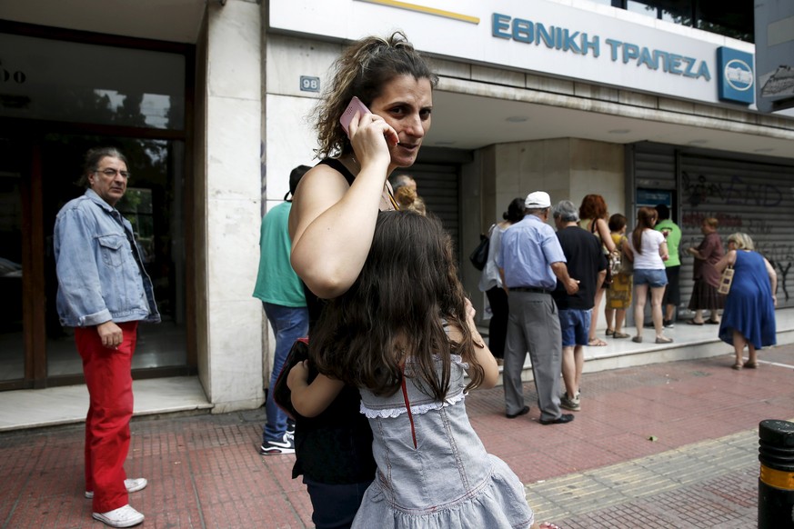Lange Warteschlangen: Eine Frau mit ihrer Tochter vor einer Bank in Athen.