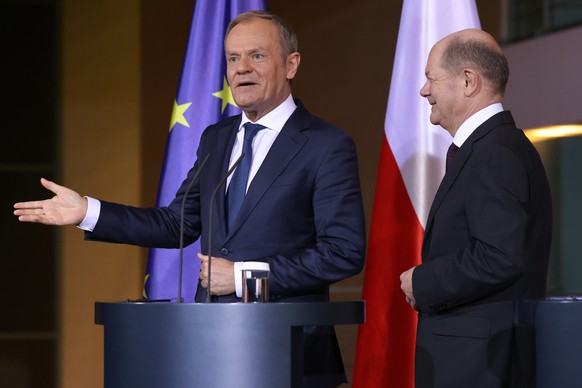epa11148285 Polish Prime Minister Donald Tusk (L) gestures as he reacts to journalists next to German Chancellor Olaf Scholz after a joint press conference at the chancellery in Berlin, Germany, 12 Fe ...