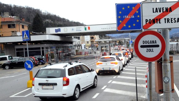 epa08282914 A view of cars queuing at the Swiss-Italian border waiting for customs in Ponte Tresa, near Varese, Italy, 10 March 2020. There are no particular restrictions for those who work across bor ...