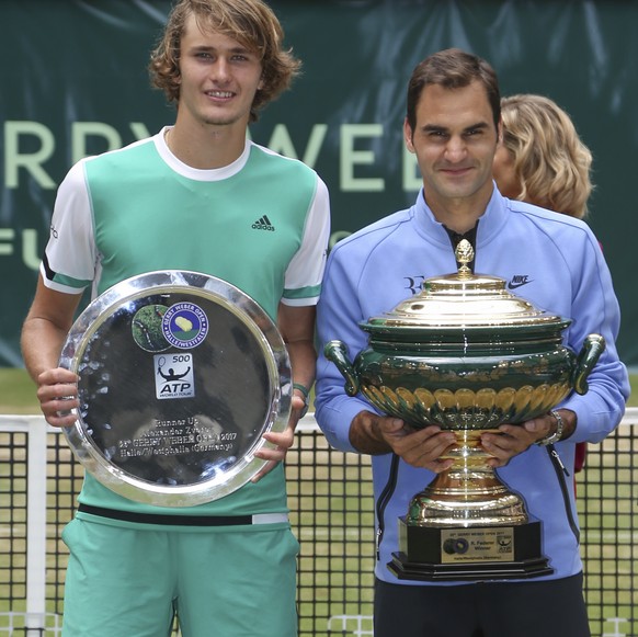 Switzerland&#039;s Roger Federer,right, and Germany&#039;s Alexander Zverev, left, pose with their trophies after the final match of the Gerry Weber Open tennis tournament in Halle, Germany, Sunday, J ...