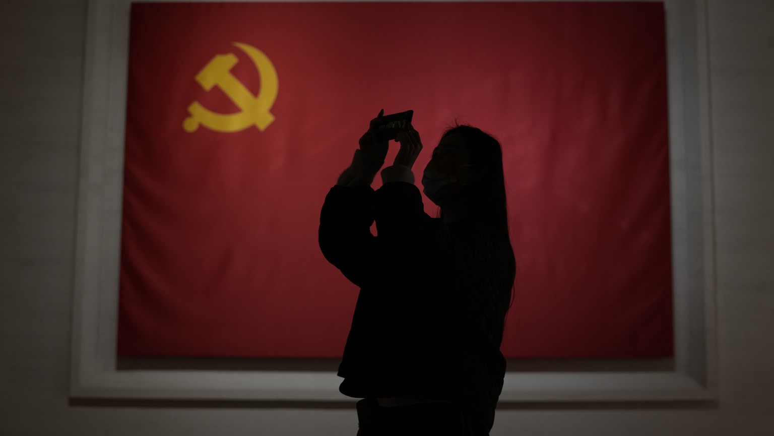 A visitor to the Museum of the Communist Party of China is silhouetted near the Chinese Communist Party flag in Beijing, China, Friday, Nov. 12, 2021. Chinese leader Xi Jinping emerges from a party co ...