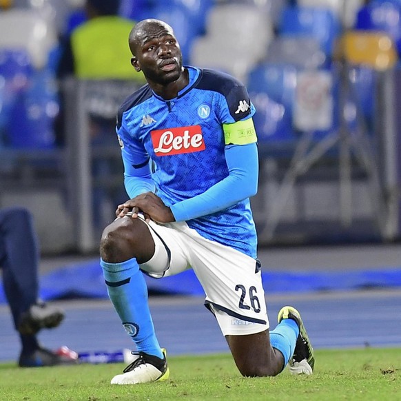 epa08060868 Turkish referee Cuneyt Cakir (C) shows the yellow card to Napoli&#039;s Kalidou Koulibaly at the end the UEFA Champions League Group E soccer match between SSC Napoli and KRC Genk at the S ...