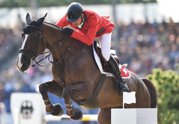 epa04891841 Romain Duguet of Switzerland jumps with his horse Quorida de Treho over an obstacle in the third round of the Show Jumping Team Final Competition during the FEI European Championships in A ...