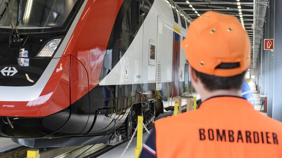 Un ouvrier de Bombardier marche a cote du nouveau train lors de la premiere presentation du nouveau train a deux etages de Bombardier pour les CFF ce lundi 8 juin 2015 a Villeneuve. (KEYSTONE/Jean-Chr ...