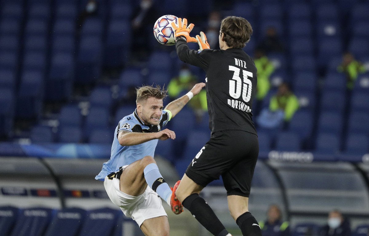 Dortmund's goalkeeper Marwin Hitz, right, saves on Lazio's Ciro Immobile during the Champions League group F soccer match between Lazio and Borussia Dortmund at the Olympic stadium in Rome,  ...