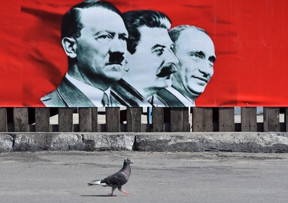 Ein Plakat in Kiew zeigt Putin neben Hitler und Stalin.