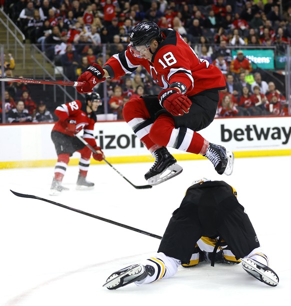 New Jersey Devils left wing Ondrej Palat (18) leaps over Pittsburgh Penguins defenseman Marcus Pettersson (28) during the second period of an NHL hockey game, Tuesday, April 2, 2024, in Newark, N.J. ( ...