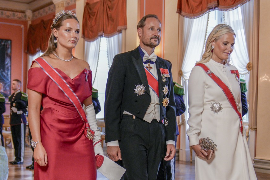 epa12193429 Norwegian Princess Ingrid Alexandra (L), Crown Prince Haakon (C) and Crown Princess Mette-Marit (R) arrive for the gala dinner in honour of visiting French President Macron, at the Royal P ...