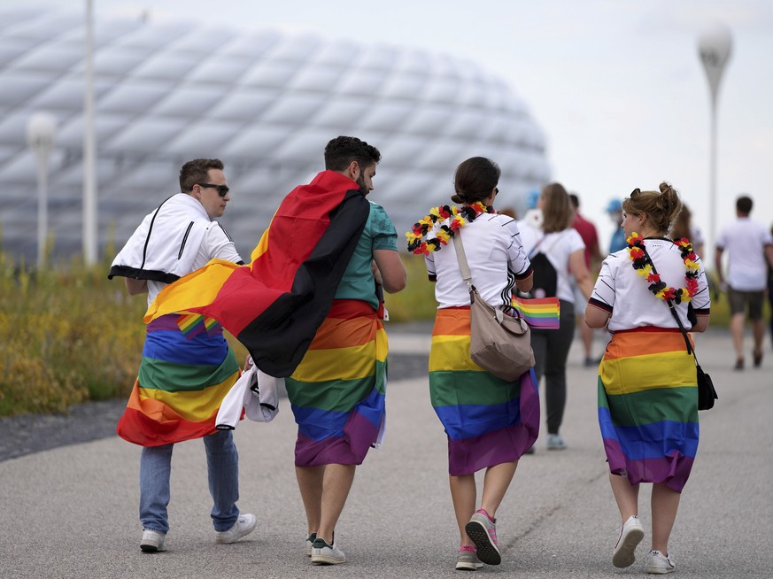 Football supporters are seen with LGBT pride flags on their way to the stadium before the Euro 2020 soccer championship group F match between Germany and Hungary at the Allianz Arena in Munich, German ...