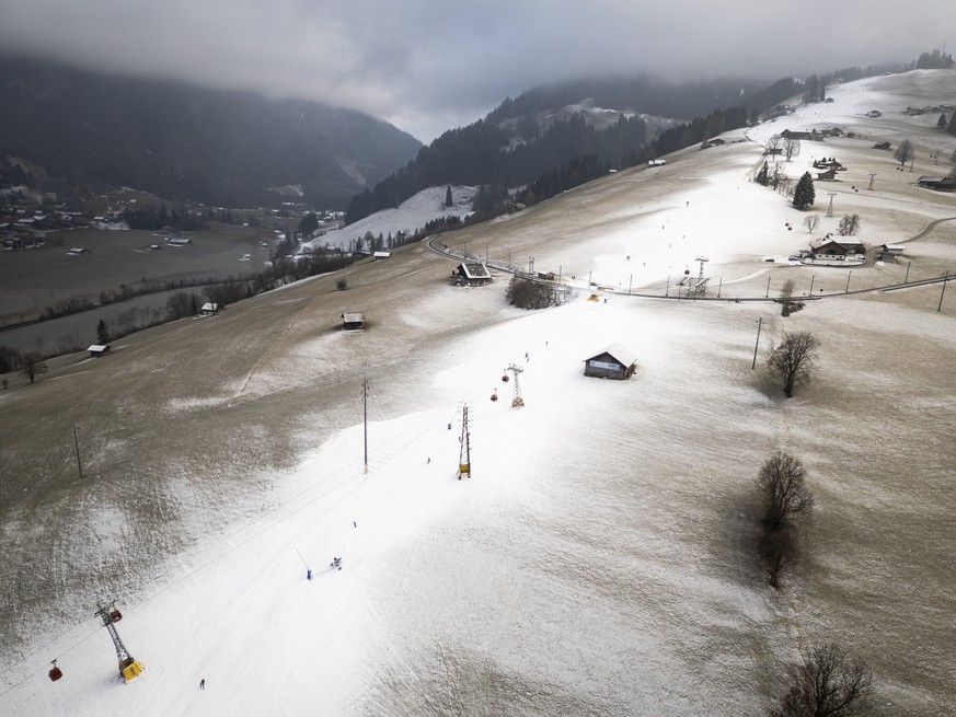 Luftaufnahme einer kuenstlich beschneiten Piste mit Schneekanonen auf den Skipisten der Gstaad Bergbahnen, unter gefrierendem Nebel, am Dienstag, 30. Dezember 2025, zwischen dem Rinderberg und Zweisim ...