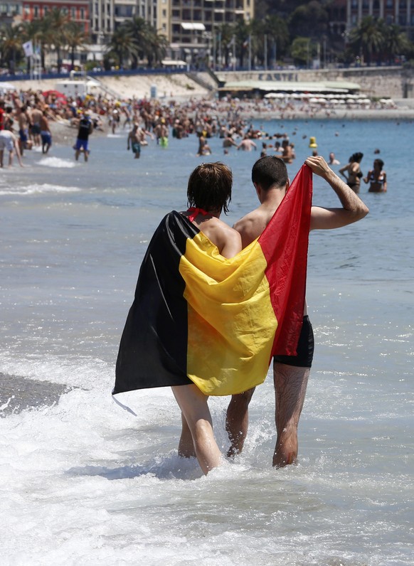 Football Soccer - Euro 2016 - Nice, France, 22/6/16 - Belgium fans walk on the beach ahead of the game against Sweden in Nice, France. REUTERS/Eric Gaillard
