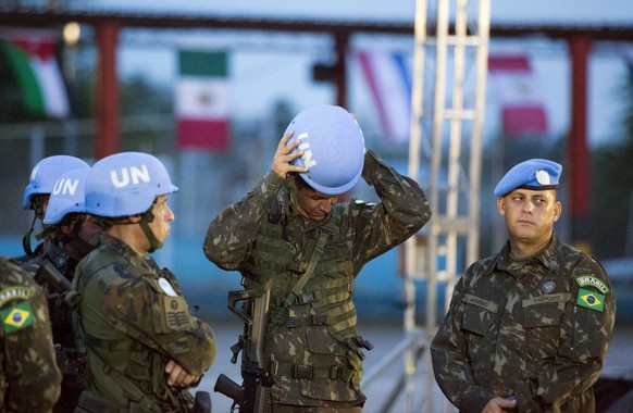 A United Nations peacekeeper from Brazil fixes his helmet before the end of operations ceremony for the United Nations Stabilization Mission in Port-au-Prince, Haiti, Thursday, Oct. 5, 2017. The U.N. ...