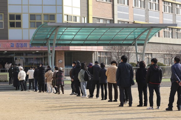 People wait in line to cast their votes for presidential election at a local polling station in Anyang, South Korea, Wednesday, March 9, 2022. South Koreans were voting for a new president Wednesday,  ...