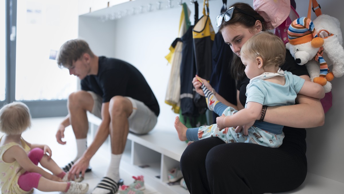 THEMENBILD ZUR LANCIERUNG DER KITA-INITIATIVE --- Betreuungspersonal hilft Kleinkindern beim Anziehen der Schuhe und Sonnenschutzkleidung, bevor es zum Spielen in den Aussenbereich der Kita 6a der Sti ...