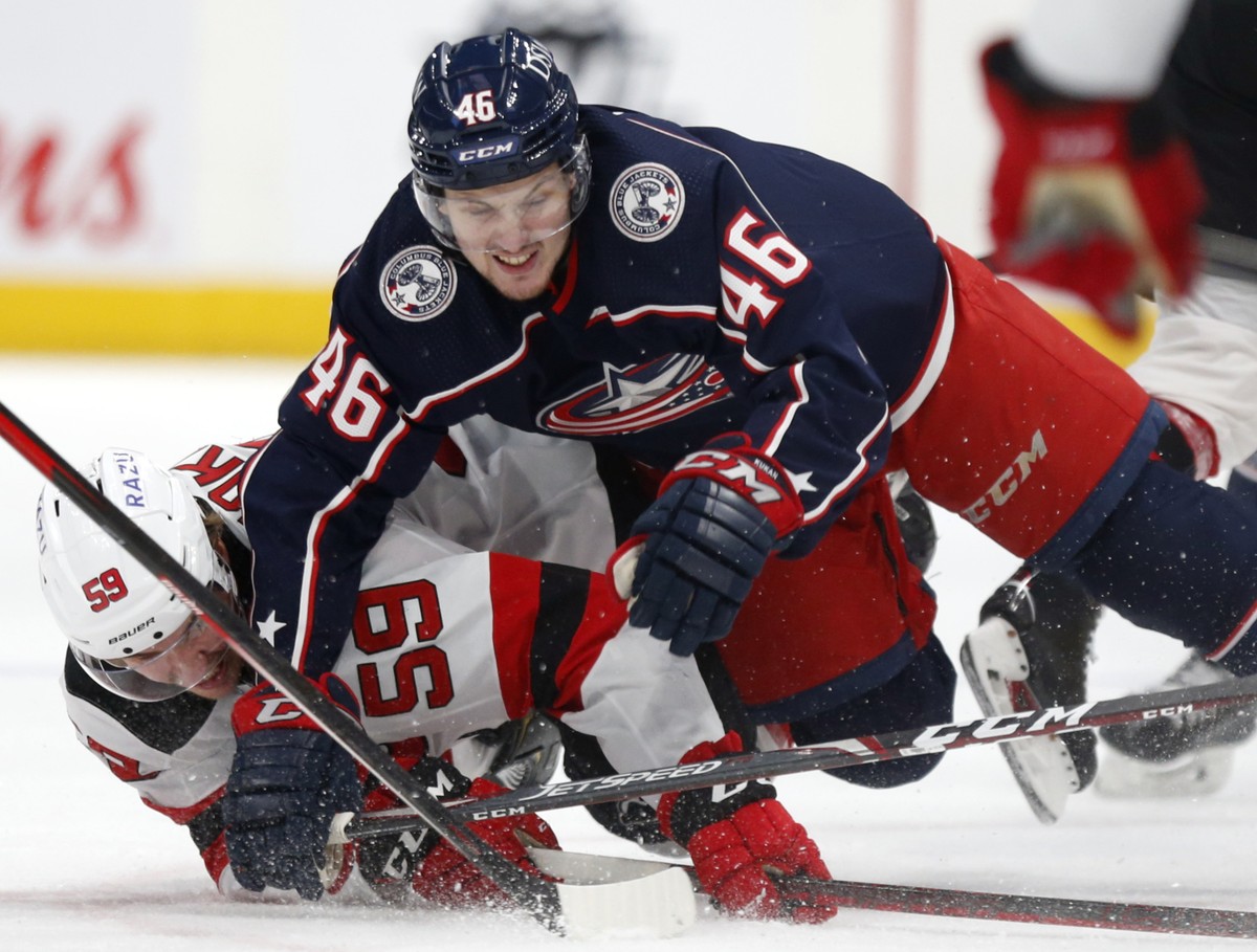 Columbus Blue Jackets defenseman Dean Kukan, top, collides with New Jersey Devils forward Janne Kuokkanen during the second period of an NHL hockey game in Columbus, Ohio, Saturday, Jan. 8, 2022. (AP  ...