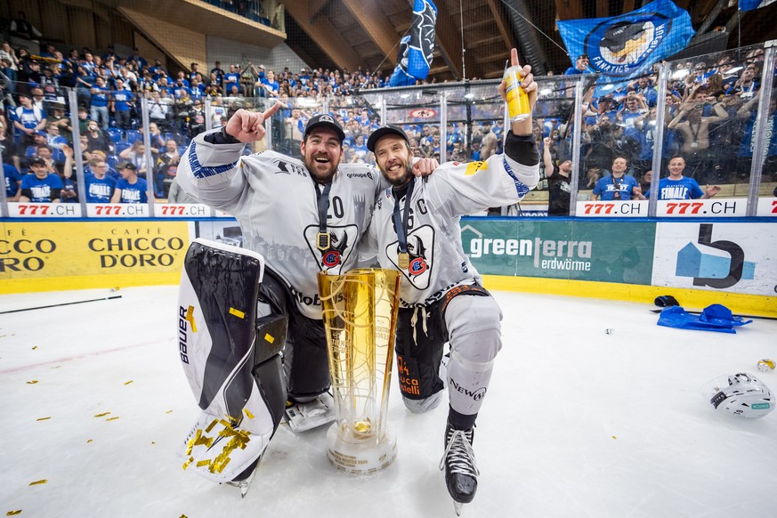 Torhueter Reto Berra und Julien Sprunger (HCFG) feiern den Meistertitel mit dem Pokal nach ihrem Sieg gegen Davos in der Verlaengerung im siebten Eishockey Playoff Finalspiel der National League zwisc ...